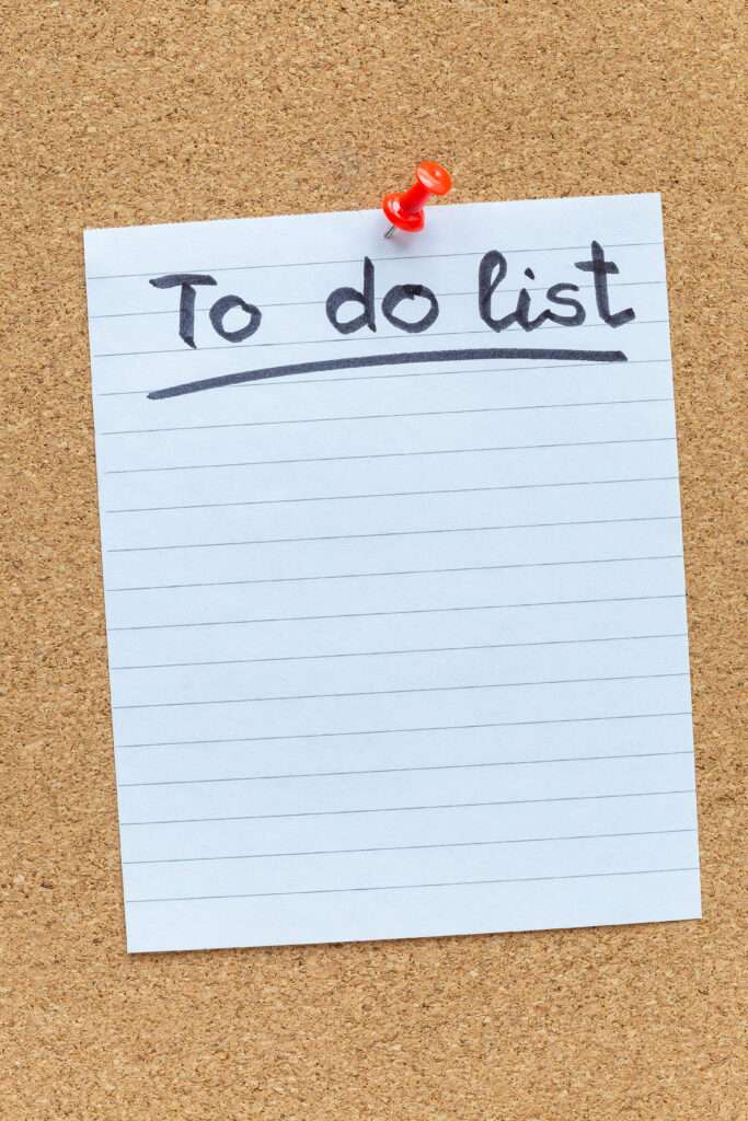 Checkliste Umzug 2 Umzugsunternehmen Hannover - Ein liniertes Blatt Papier mit der Aufschrift „To-Do-Liste“ wird mit einer roten Reißzwecke an eine Pinnwand geheftet. Der Rest des Blattes ist leer und kann als Checkliste für den Umzug ausgefüllt werden. Umzugsunternehmen Seelze.
